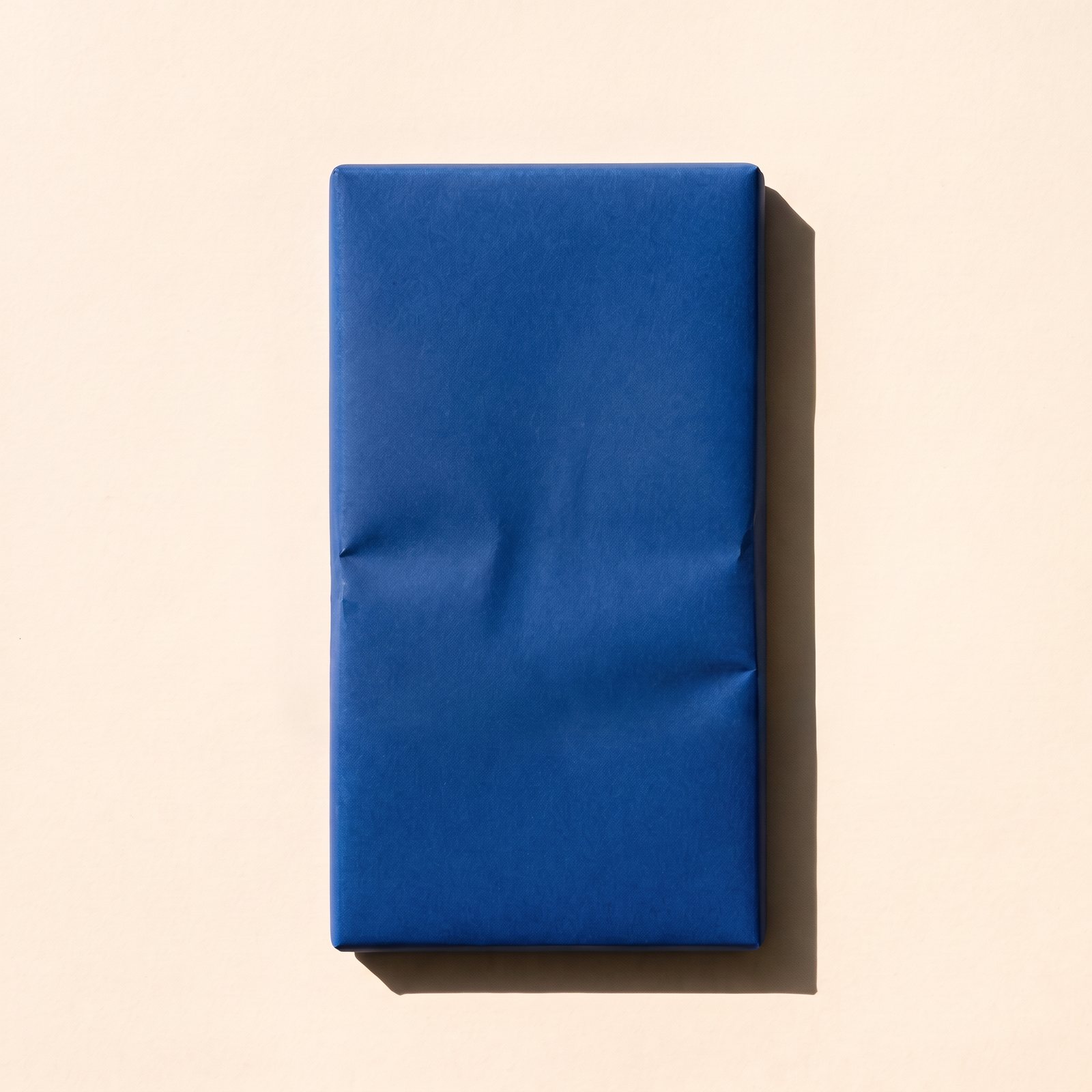A chocolate bar wrapped in plain Fazer-blue paper, seen from above